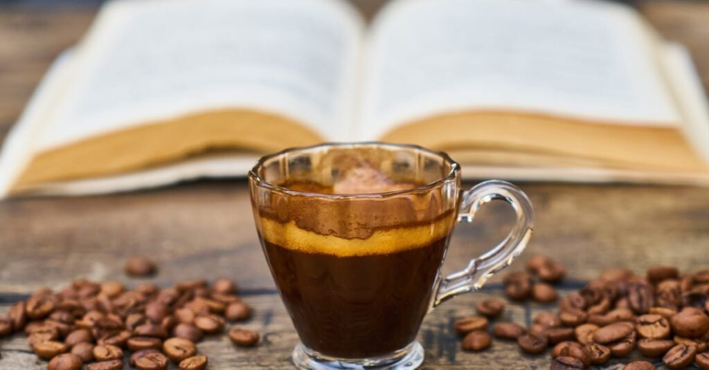 A rich espresso cup surrounded by beans and an open book, perfect for a relaxing break.